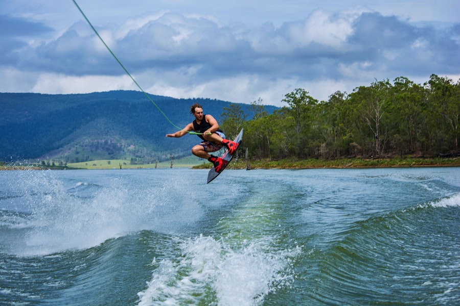 Man wakeboarding on lake, holding rope behind boat.