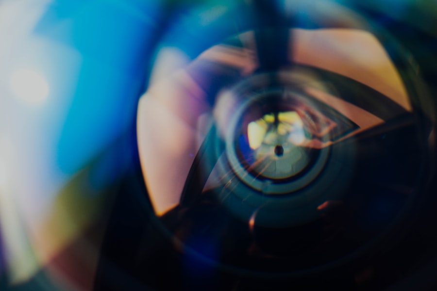 Close-up of camera lens reflecting a person.