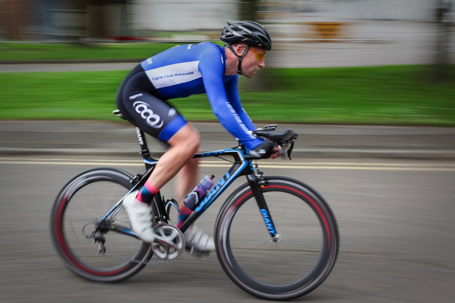  man in a blue jersey riding a bike on a sunny day.
